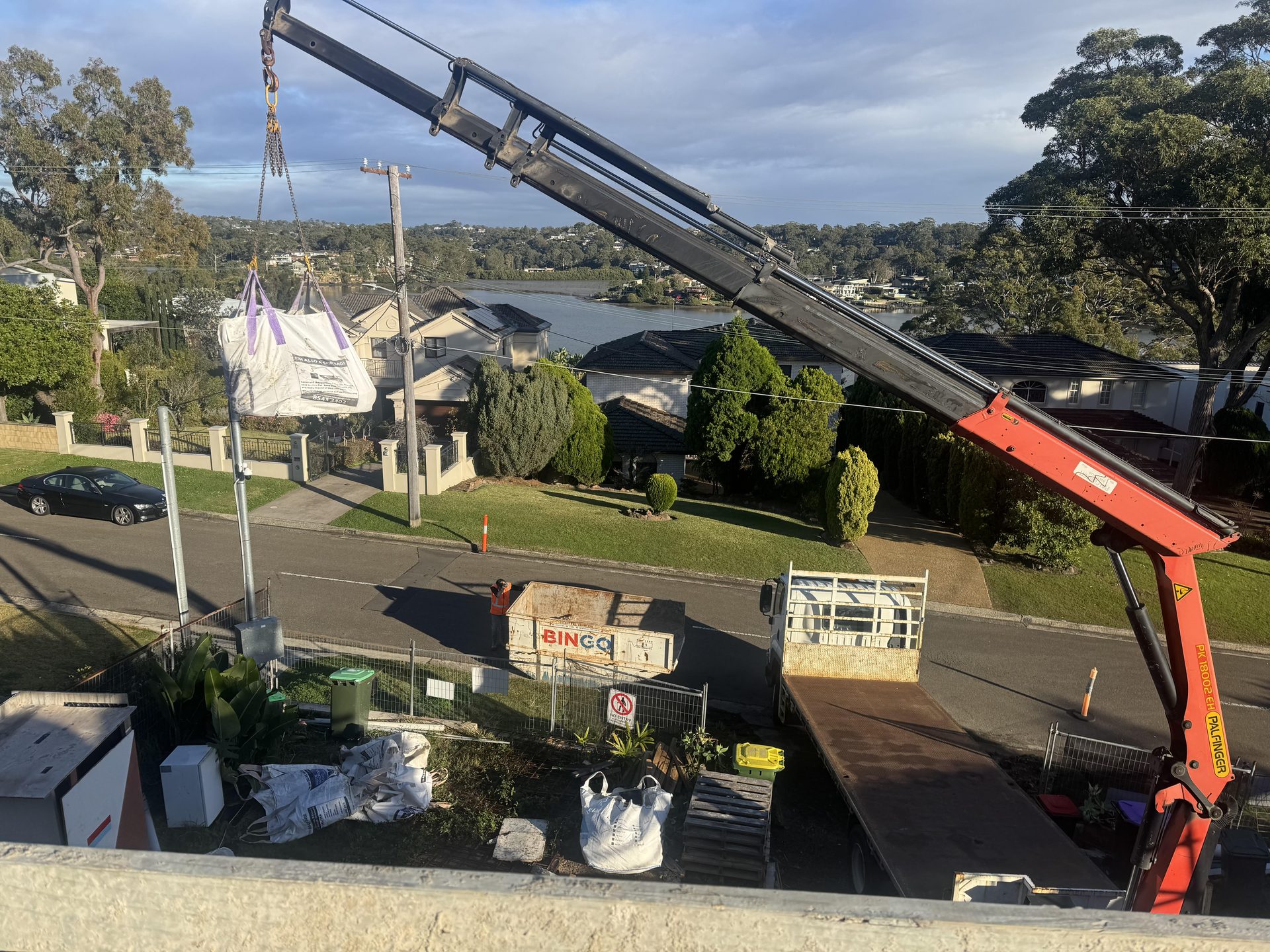 Crane truck lifting a bulk bag over a residential Sydney street