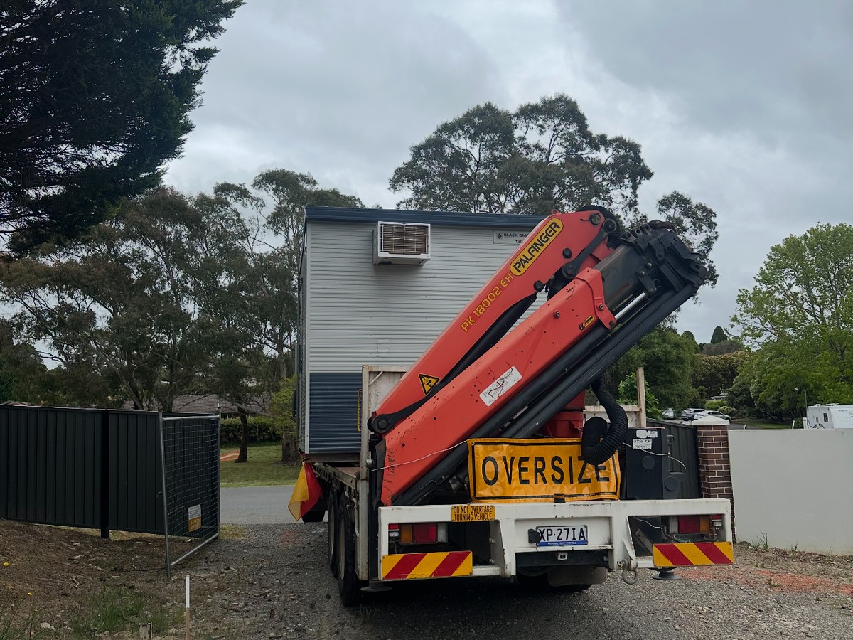 Crane truck with oversize load signage on a residential job site