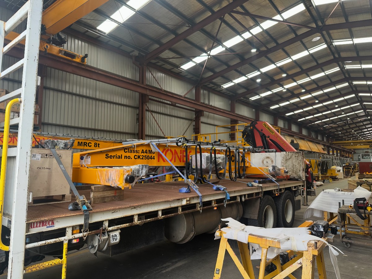Overhead crane component loaded on flatbed truck in a warehouse